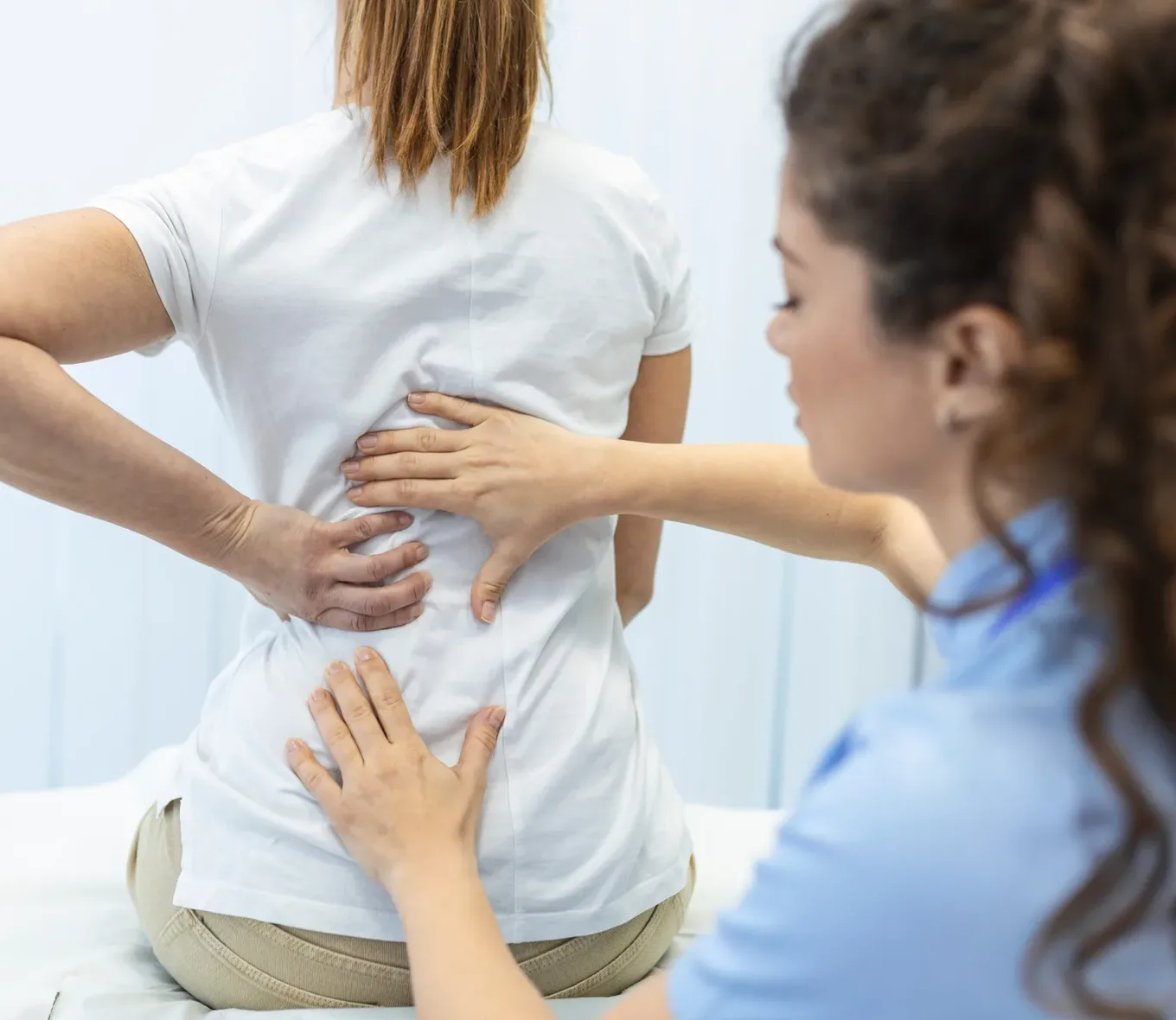 A chiropractor assessing a patient’s lower back